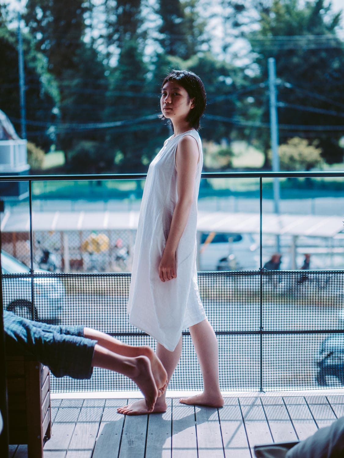 a girl with other's legs on balcony