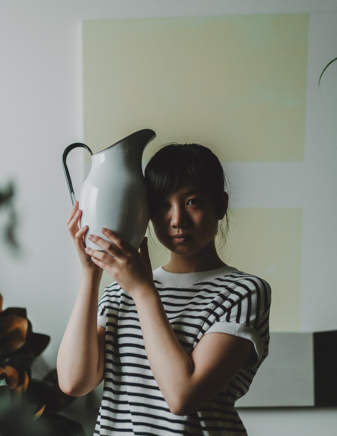 A girl holding up a pitcher of water