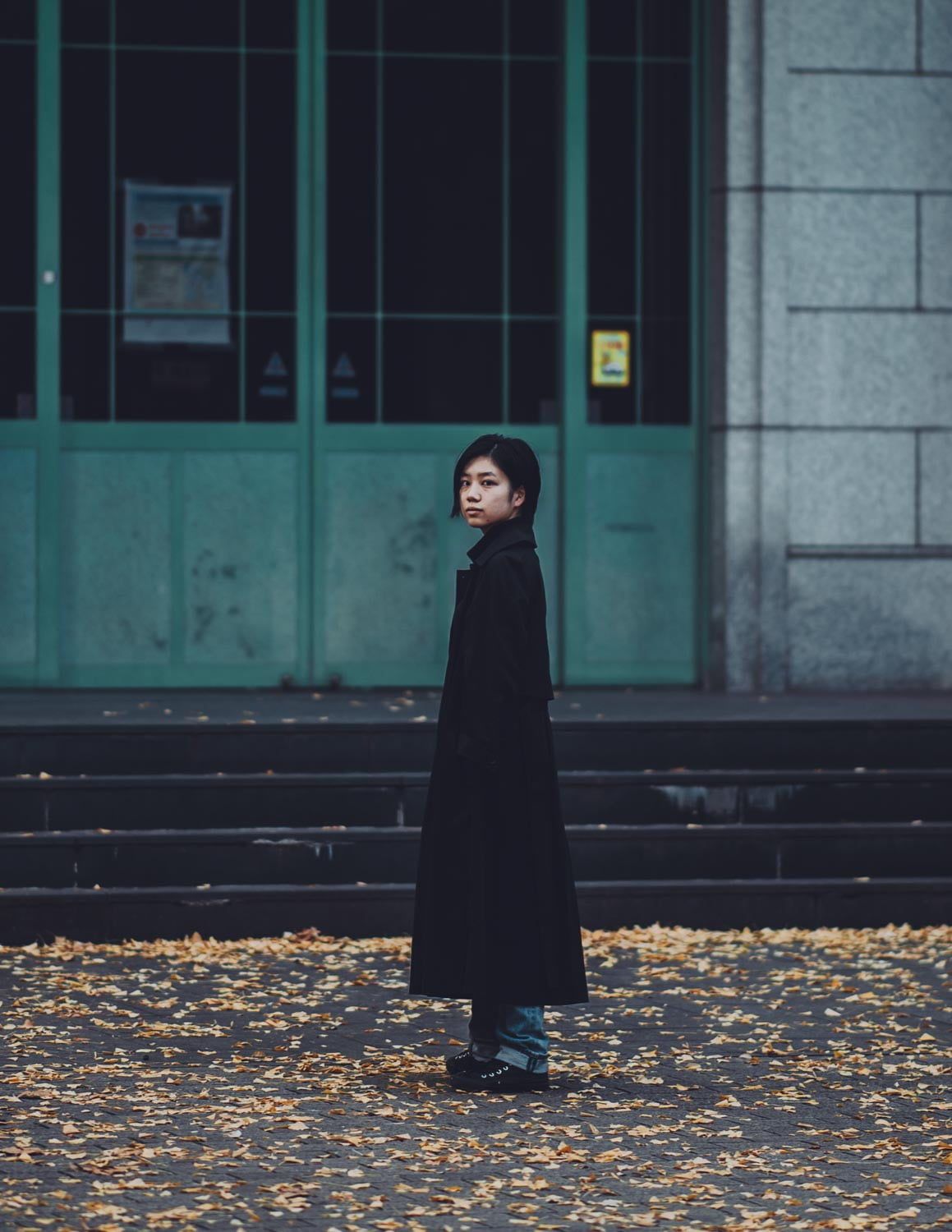 a girl standing in front of an iron door